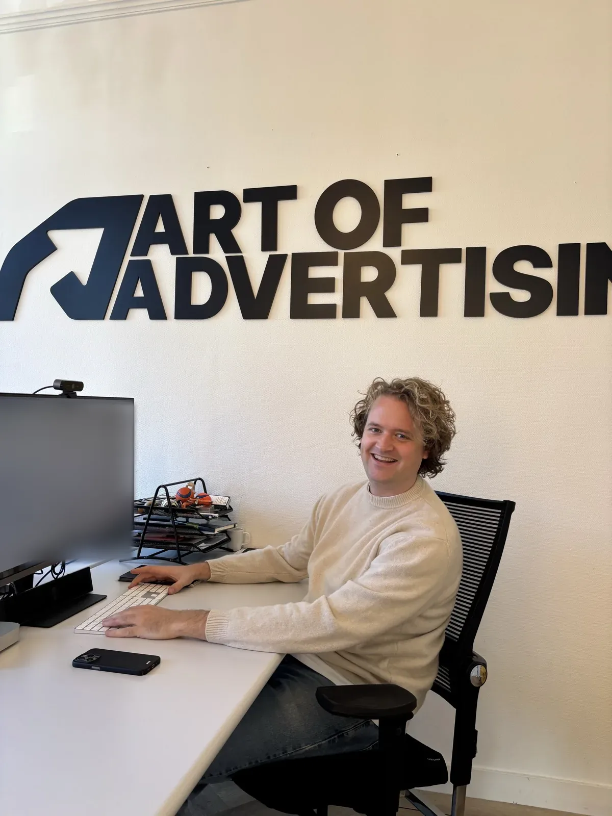 Een collega van Art of Advertising achter het bureau in ons kantoor in Groningen