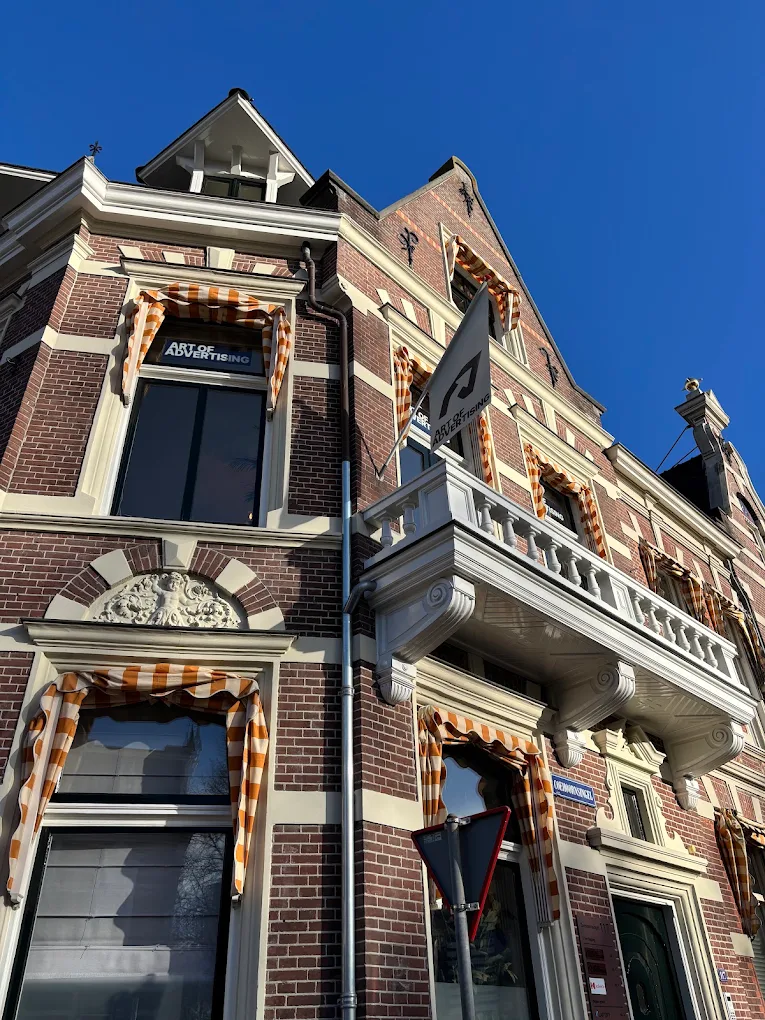 The facade of Coehoornsingel 117 with the balcony and the Art of Advertising flag